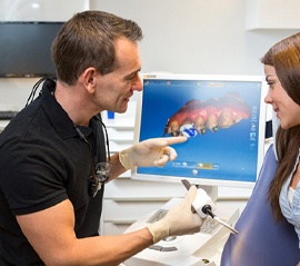 Dentist and patient consulting over CEREC crown technology