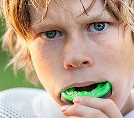 Teen placing green mouthguard