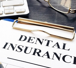 Close-up of dental insurance form with pen and clipboard