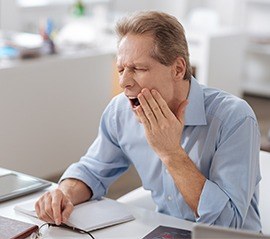 Man holding jaw in pain