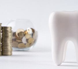tooth next to a pile of coins