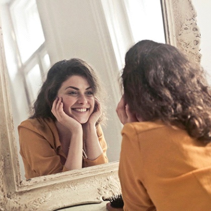 Woman looking at her smile in mirror