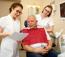 Senior man learning about options for paying for dentures
