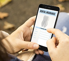 Woman looking at dental insurance form on phone