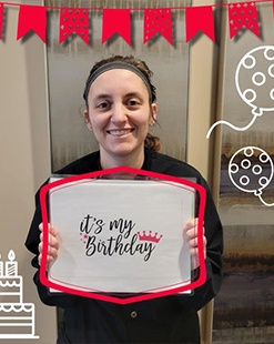 Young woman in Fargo dental office holding sign saying it's my birthday