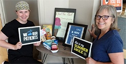 Dental team member and patient holding small signs in dental office