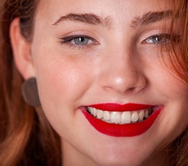 Close up of woman with bright red lipstick smiling 