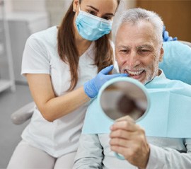 a patient smiling after fixing a failed dental implant