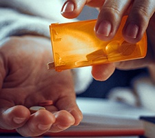 Man pouring pain medication into his hand