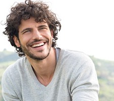 A man with dental implants in Fargo smiling outside