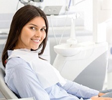 A woman smiling while visiting an implant dentist in Fargo.