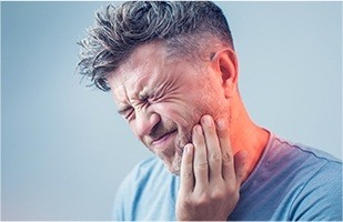 Man holding side of his face in pain