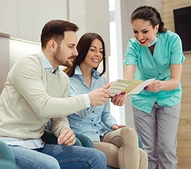 Man and woman talking to dental team member