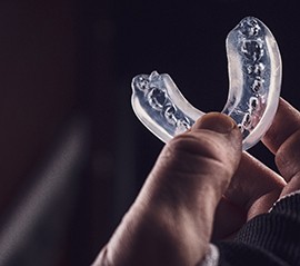 Closeup of man holding clear mouthguard