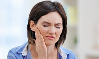 Woman holding jaw in pain