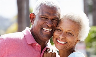 Older man and woman smiling outdoors