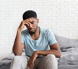 Restless man sitting on edge of bed