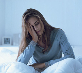 Restless woman sitting up in bed