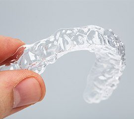 Hand holding SureSmile aligner