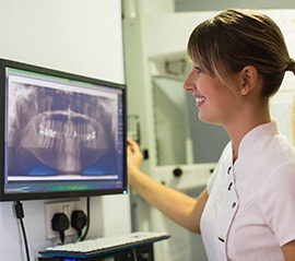 Dental team member looking at digital dental x-rays