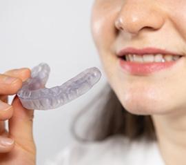 a person holding an occlusal splint for TMJ treatment