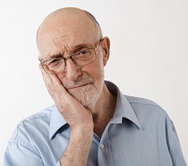 Man in pain holding jaw