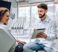 dentist showing a patient information on a tablet 