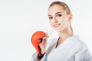 Woman with boxing glove holding a mouthguard