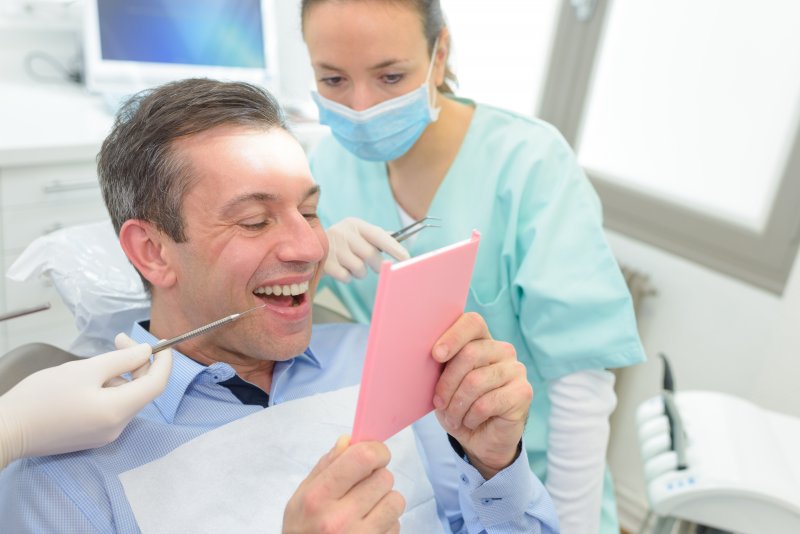 Patient looking at new dental crown in mirror