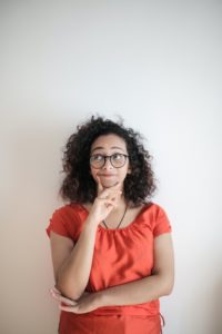 Woman in red shirt contemplating 