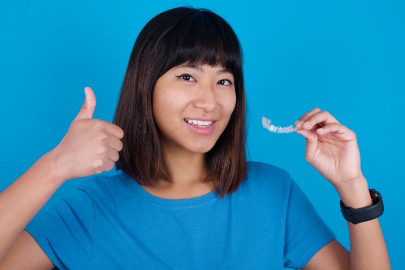 woman holding clear aligners in Fargo