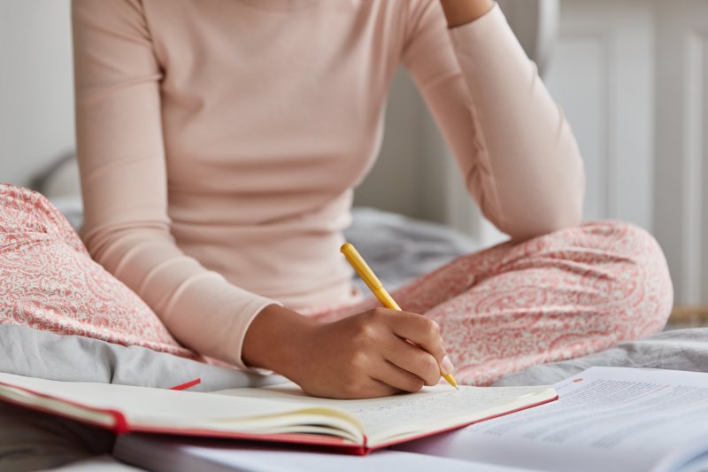 woman writing in sleep diary