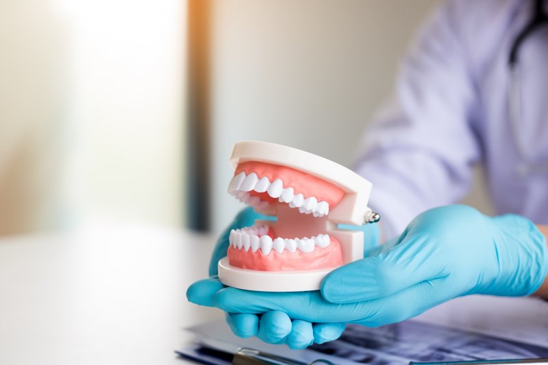 dentist holding dentures 