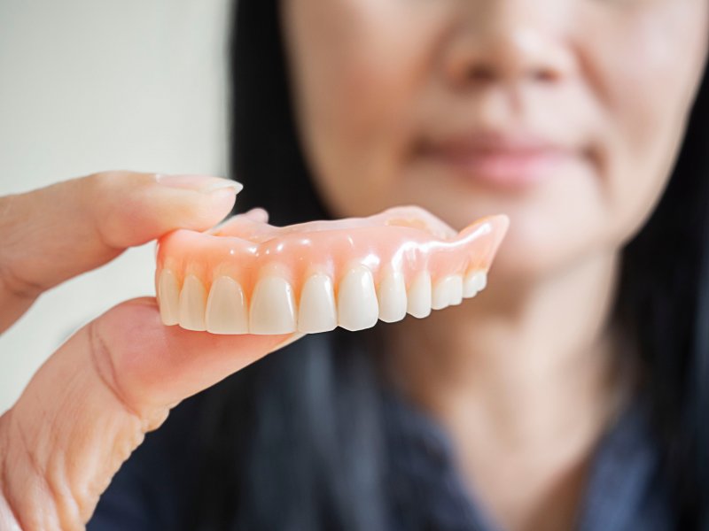 woman holding dentures