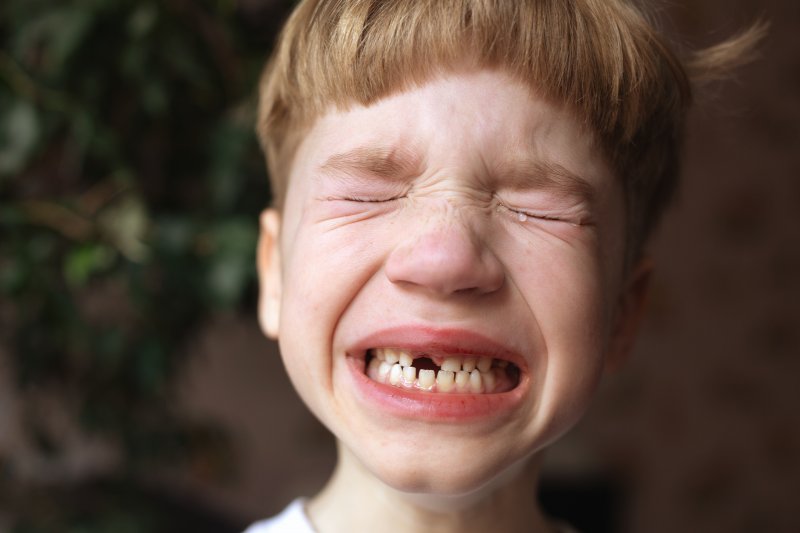 A child with a knocked out tooth crying