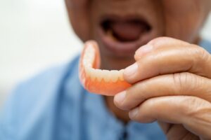 Man holding a denture. 