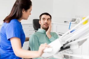 Concerned patient speaking with his dentist about gum disease treatment