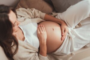 Pregnant woman holding her stomach.